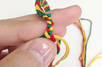 糸を二本一組にして三つ編みを編んでいく